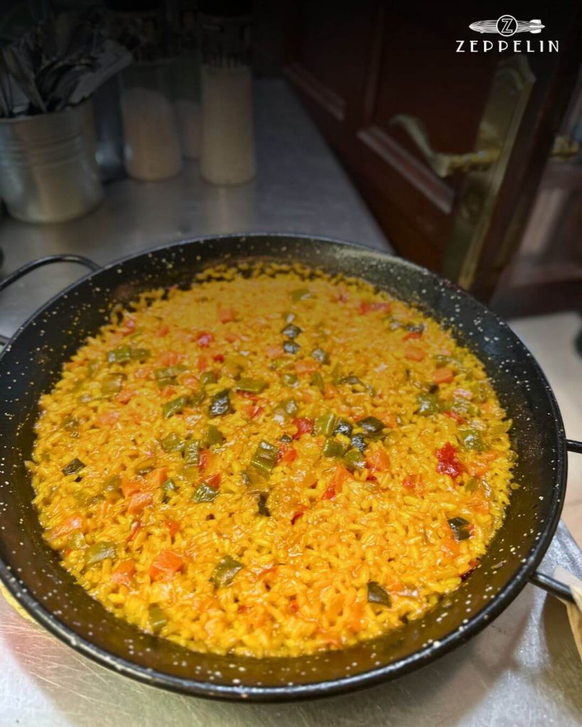 Paella servida en mesa familiar en el restaurante ZEPPELIN de Torrelodones