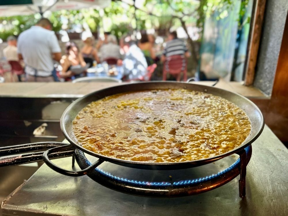 Arroz cociéndose al fuego en la terraza de Zeppelin, Torrelodones